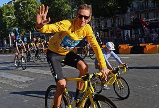 All smiles for Bradley Wiggins (Sky) as he takes a lap of honour on the Champs-Élysées. Bradley's son is decked out with a yellow bike as well.