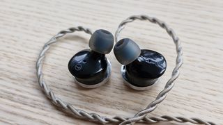 FiiO FP3 wired earbuds on a wooden surface