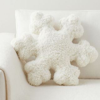 Sherpa Snowflake Shaped Pillow on a white sofa.