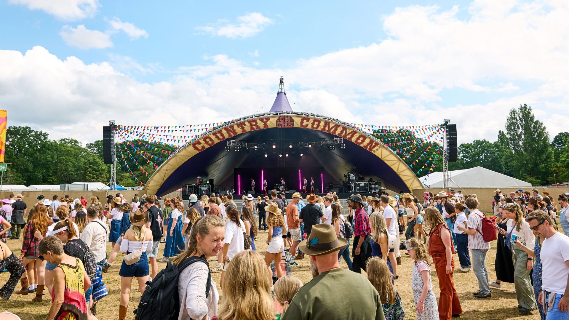 an image of the main stage at country on the common with a medium size crowd
