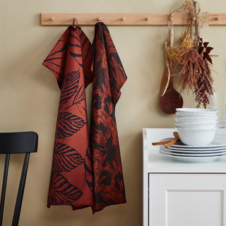 A kitchen with leaf patterned tea towels hanging up