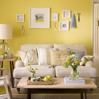 living room with yellow wall and sofa set with cushions