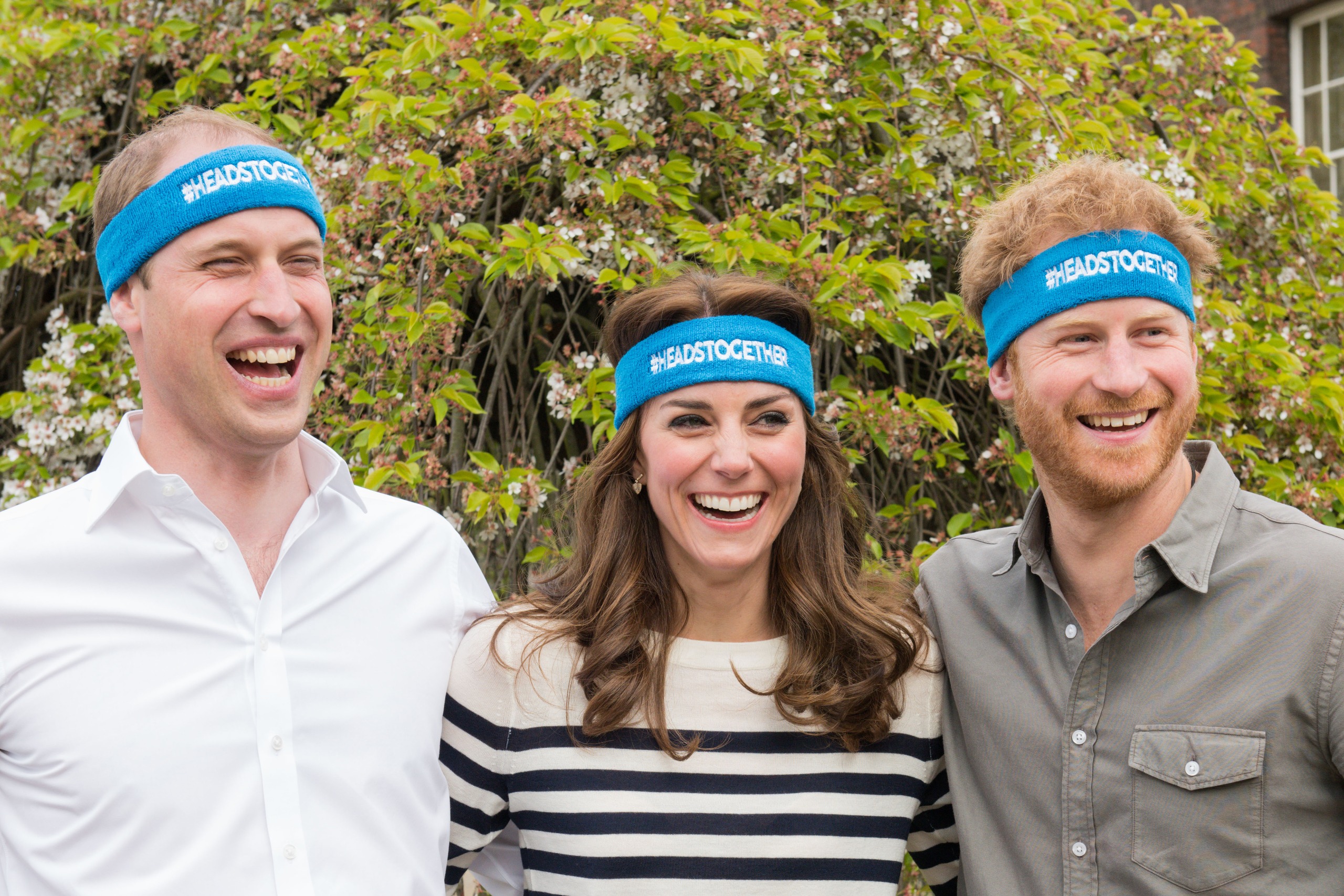 Prince William, Princess Kate and Prince Harry wearing blue sweatbands and laughing