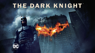 The Dark Knight foran en bygning med brændende bat-logo