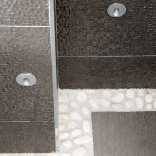 grey and brown designed wall low level shower light and white designed flooring