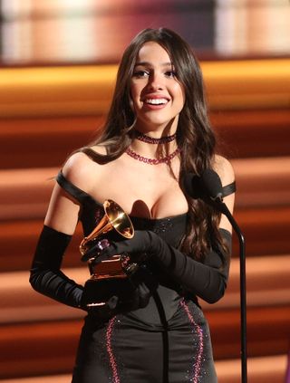 Olivia Rodrigo winning her first Grammy awards in a black bustier dress and opera gloves