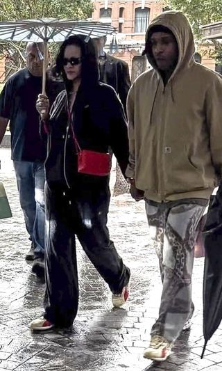 A photo of Rihanna and A$AP Rocky wearing matching beige and bright red Puma sneakers