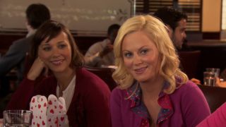 Amy Poehler and Rashida Jones sitting at a table together during Galentine's Day on Parks and Rec