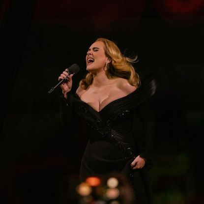 Adele wearing a custom black dress while performing onstage at Weekends with Adele 