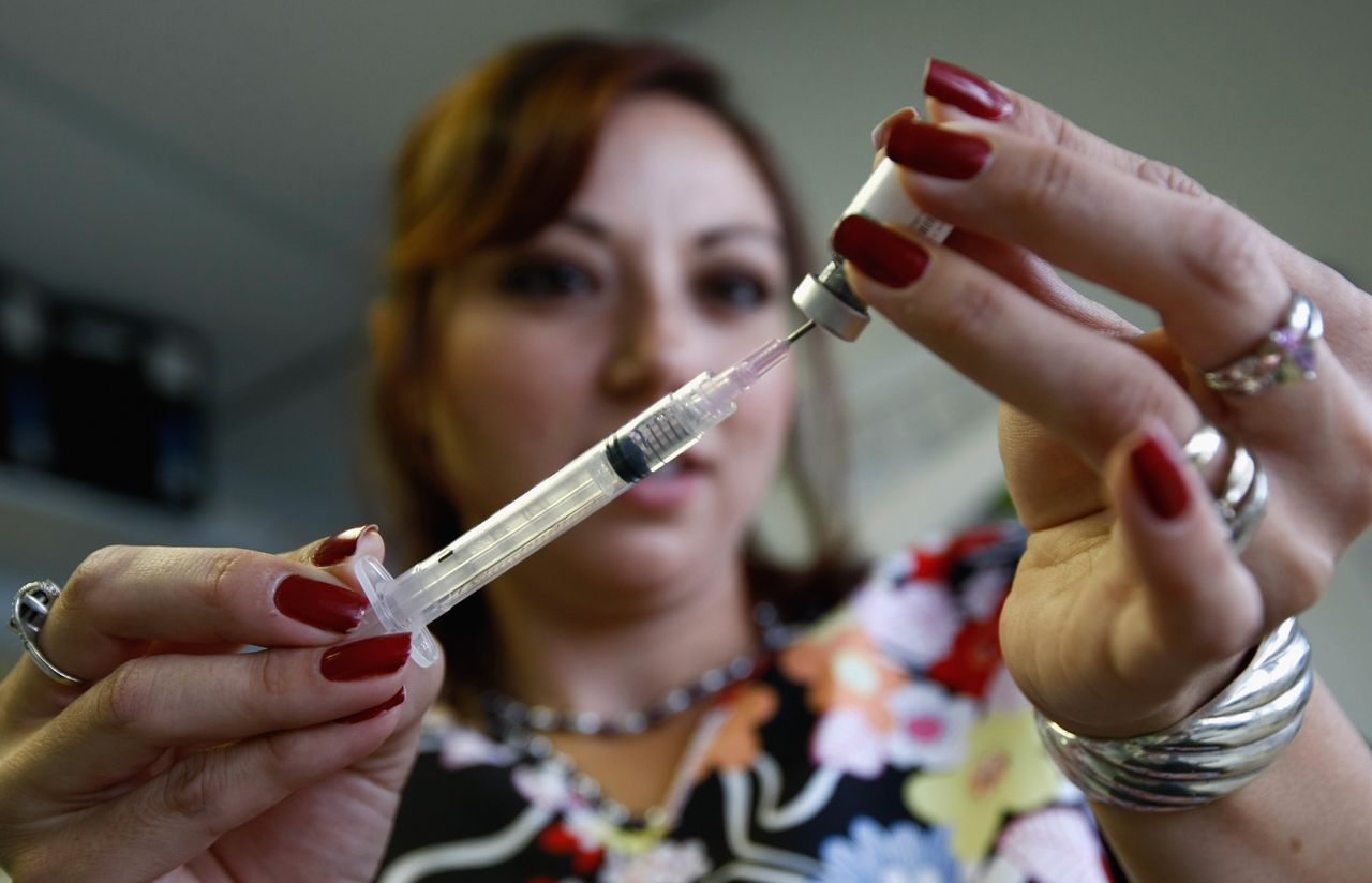 A medical assistant gets an MMR vaccine ready.