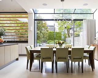 Dining area, full height glazed doors with skylight to view of garden, 9 seater dining table, bespoke chandelier, grey tiled flooring