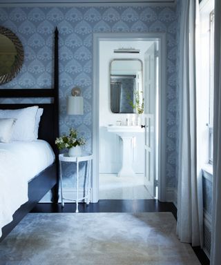Blue bathroom with ensuite, blue wallpaper, white bedding, rug, white ensuite
