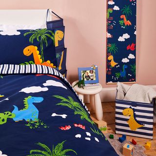 bedroom with pink wall and blue dinosaur printed beddings set