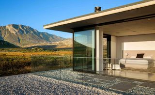 Floor to ceiling windows in a house in the middle of mountains