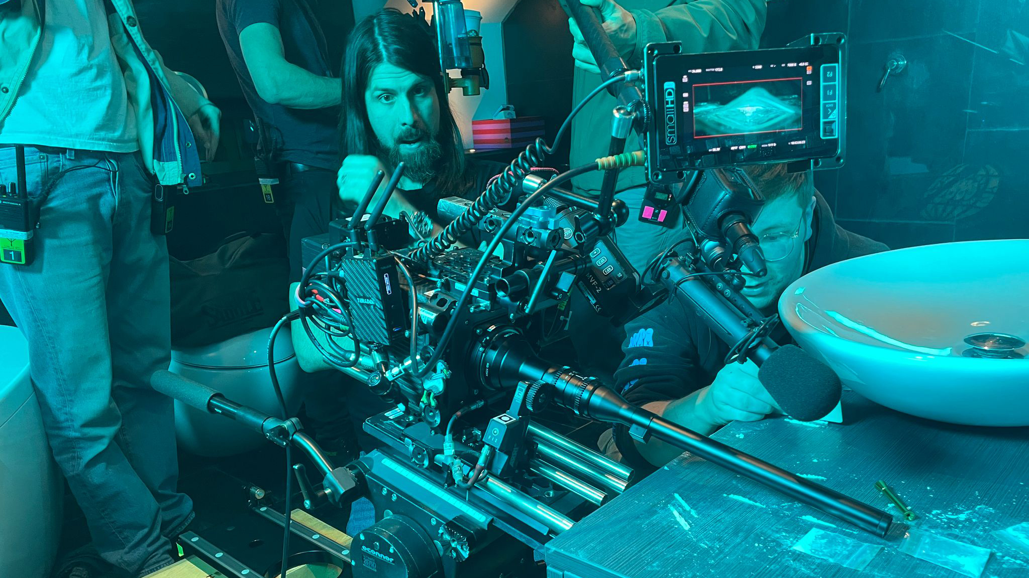 Cinematographer Andrew Roger using a large cine camera on a film set