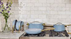 Caraway Blue Lagoon collection (pots and pans) on a gas stove top in a cream kitchen