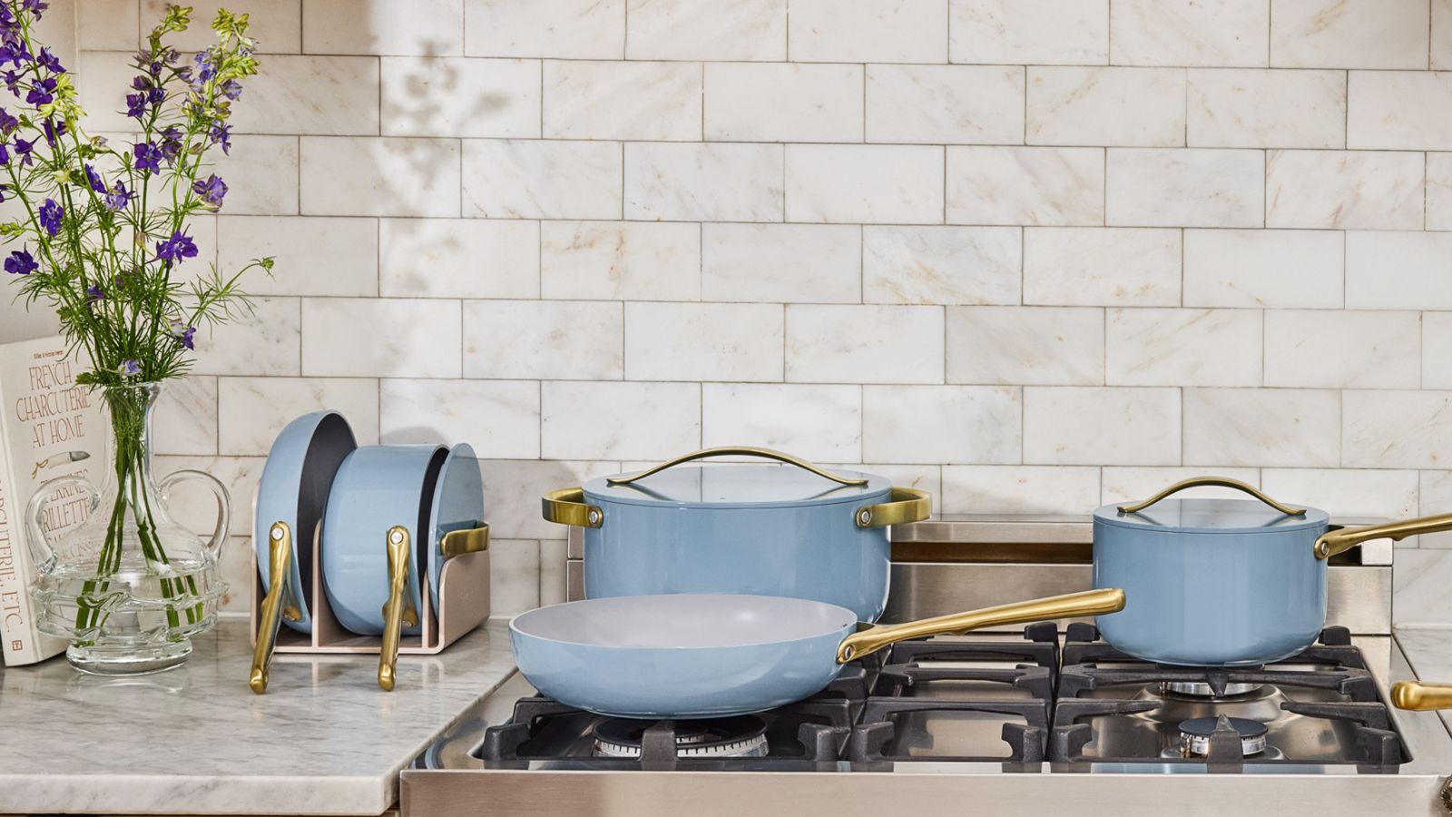 Caraway Blue Lagoon collection (pots and pans) on a gas stove top in a cream kitchen
