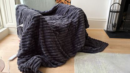The Morphy Richards EverCosy Heated Throw on a chair, being tested for our review