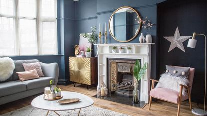 Blue living room with gold accents and period-style white fireplace