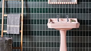 Dark green tiles in a bathroom with a pink sink to illustrate the forest green color trend