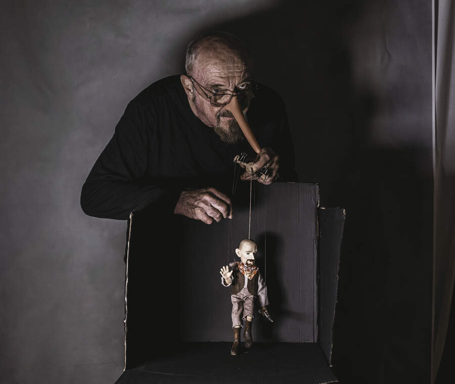 Ian Anderson with a Pinnochio-style long nose, dangling a puppet