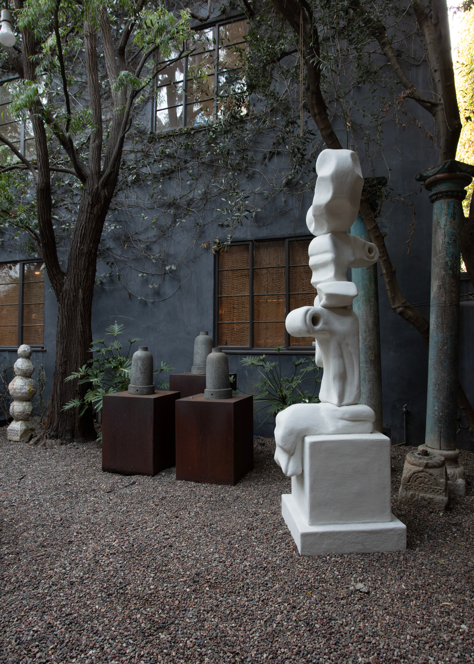 beautiful marble sculpture in a gravel courtyard with other sculptures surrounding it