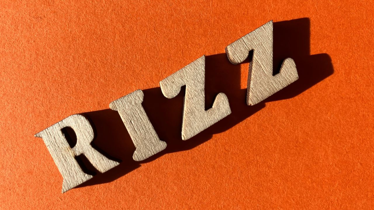 the word &quot;rizz&quot; running from left corner to right against a bright-orange backdrop