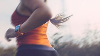 A woman running with a fitness watch