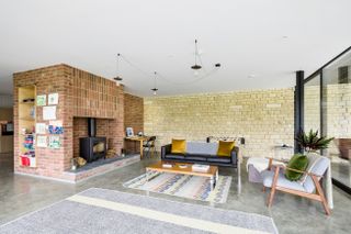 living room with large brick fireplace and log burner