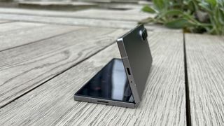 Samsung Galaxy Z Fold 6 foldable smartphone on wooden decking, half folded