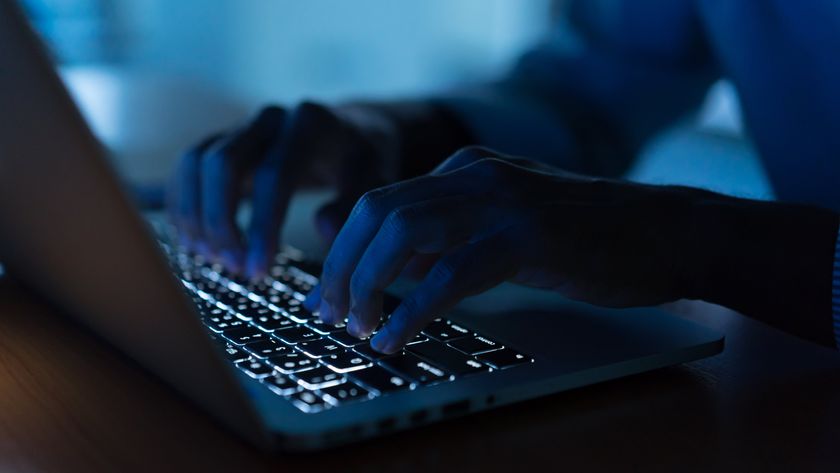 close up man hand typing on a keyboard in darkness