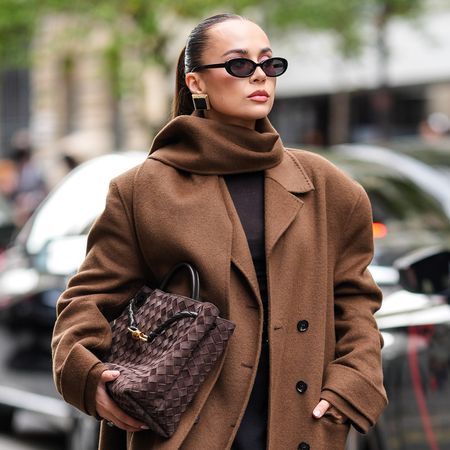 Woman wearing a scarf coat and Bottega Veneta bag
