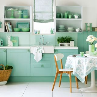 kitchen with mint green wall and white flooring with mint green cabinets