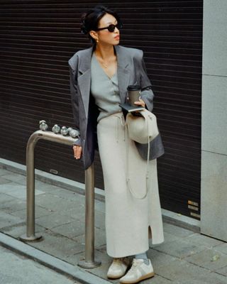 The influencer wore a gray blazer with a maxi skirt and vest.