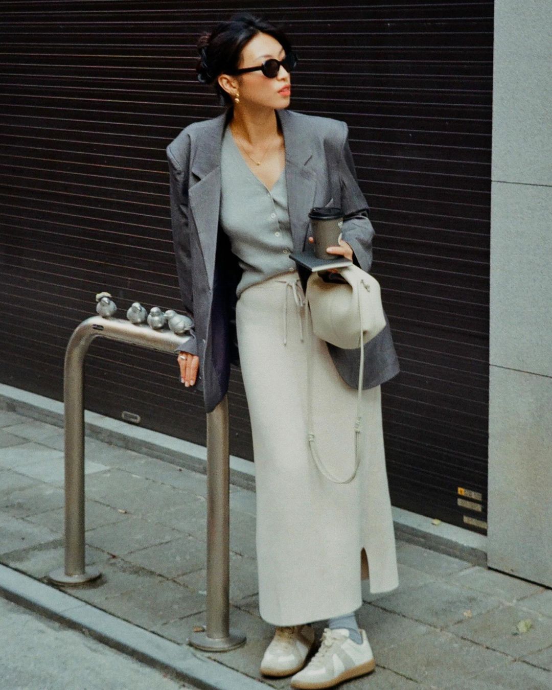Influencer wears a grey blazer with a maxi skirt and vest.