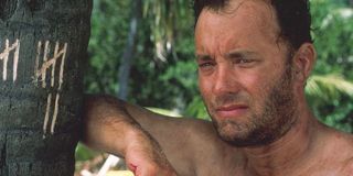 Tom Hanks leaning on a tree with tally marks in Cast Away