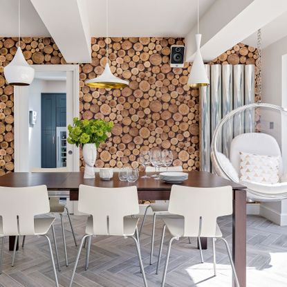 dining room with wallpaper and potted plant and glasses on dining table