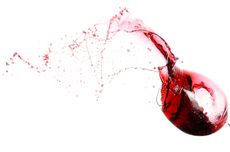 Glass of red wine spilling