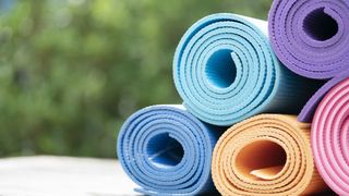 The best yoga mats in 2022: image shows pile of yoga mats