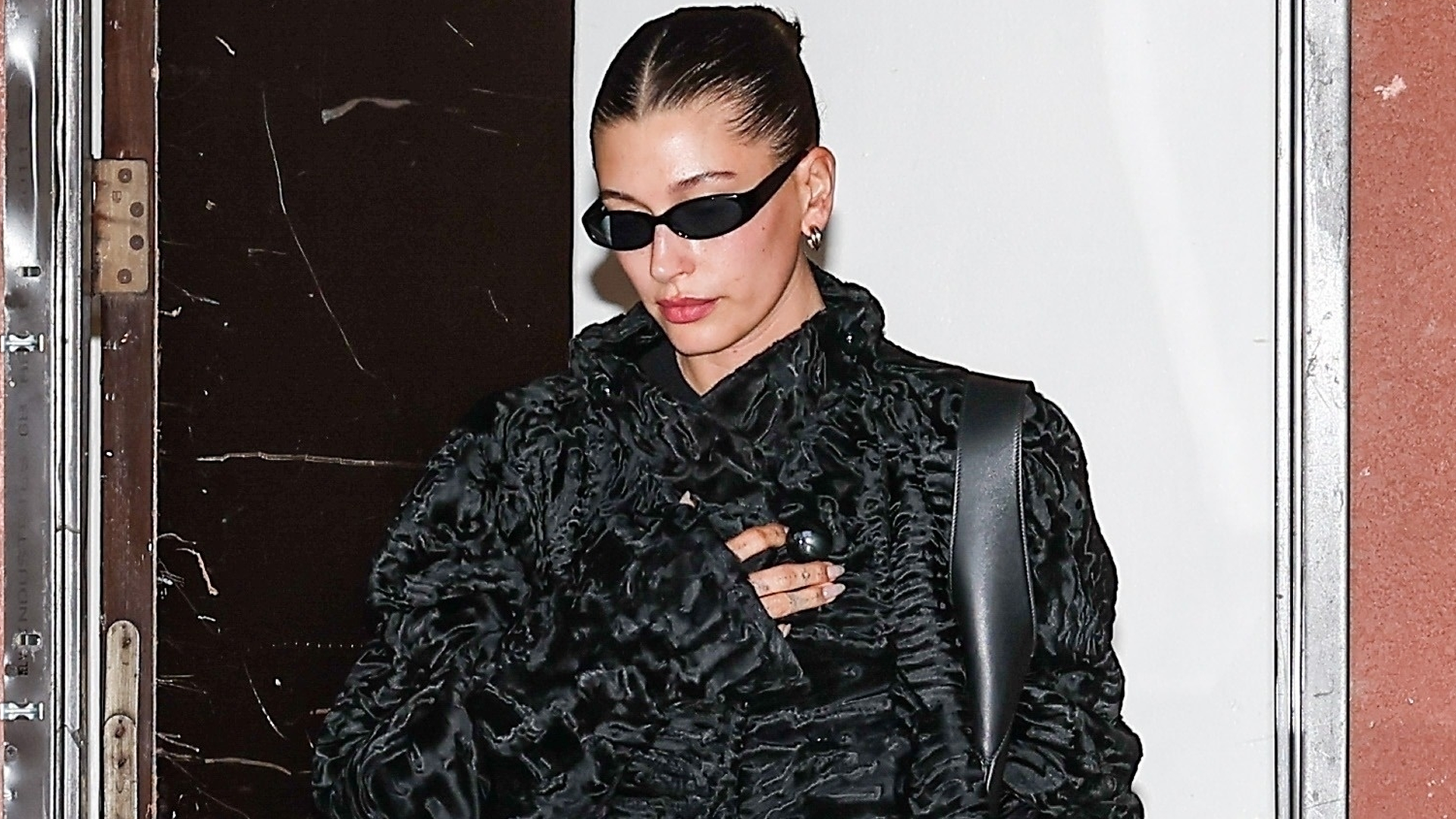 Hailey Bieber added some texture to her all-black outfit in a shearling coat, velvet pants, and a leather tote bag