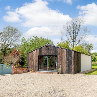 garden shed with wooden wall glass door and trees