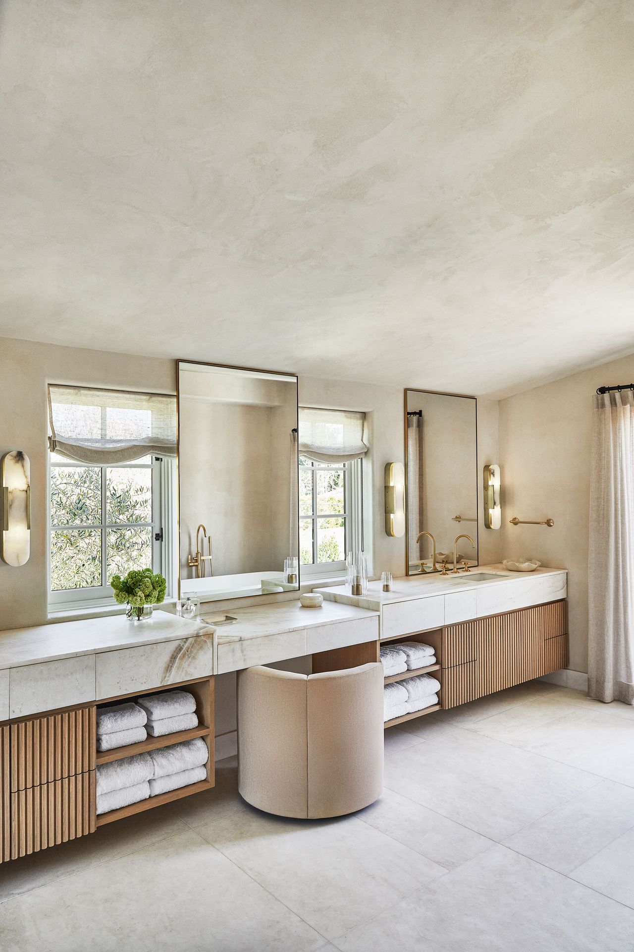 A neutral bathroom with wooden paneled units and stone basin