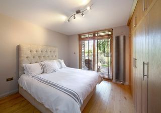 bedroom with wooden flooring and headboard