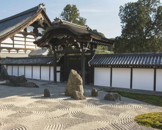 An example of Japanese garden ideas showing a gravel path next to a temple building
