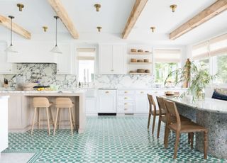 A white kitchen with a colorful tiled floor