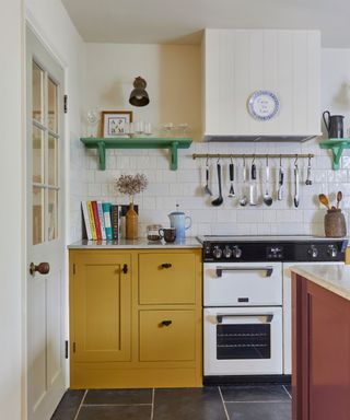 A kitchen with yellow cabinets, a white oven and stacks of cookbooks on the counters