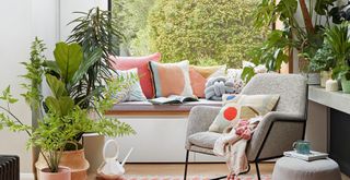 Living room with window seat surrounded by plants