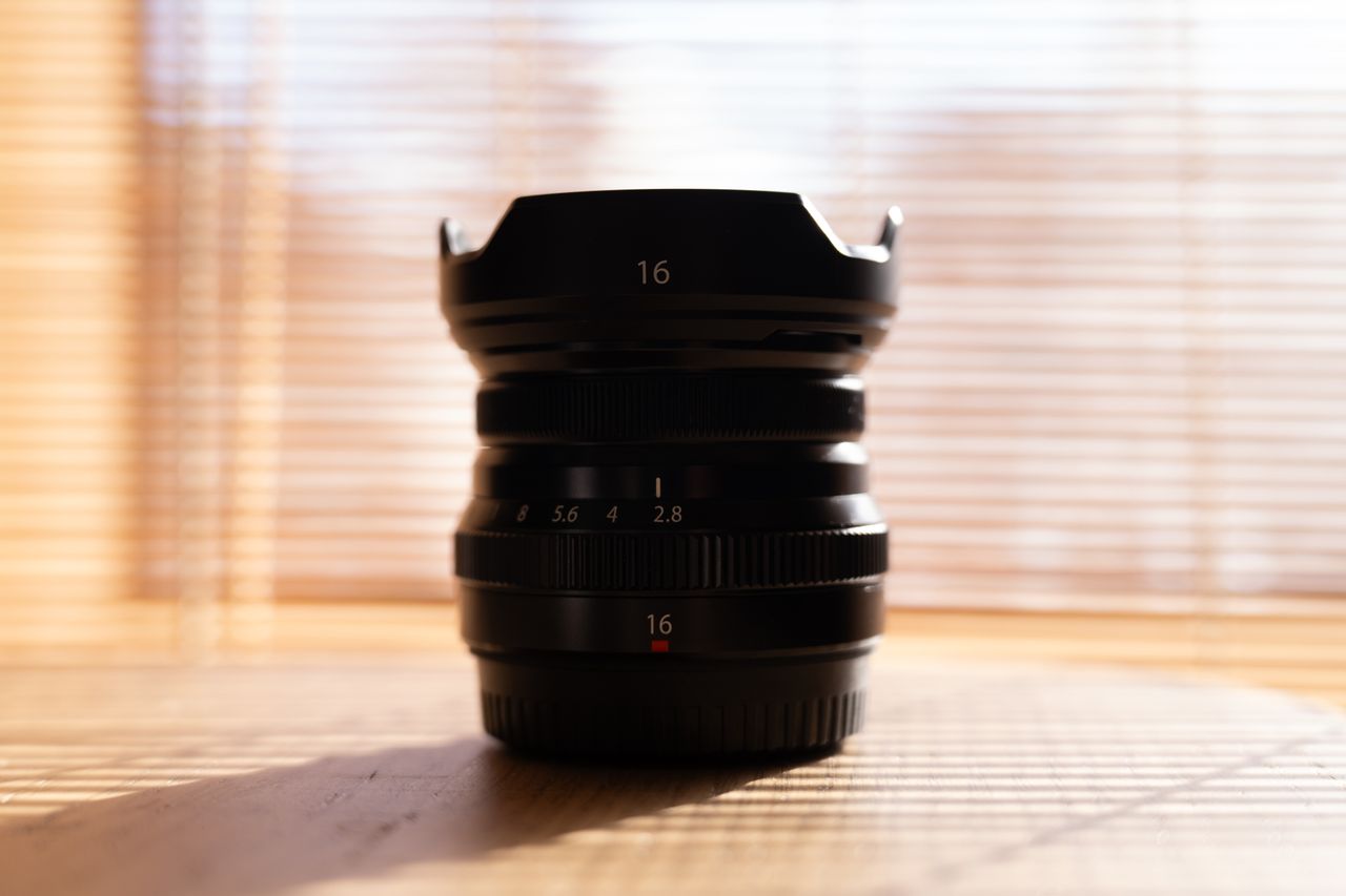 A photo of a Fujifilm lens in front of a bright window.