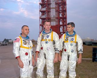 Astronauts (left to right) Gus Grissom, Ed White, and Roger Chaffee posing in front of Launch Complex 34.