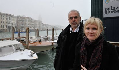 An older male and younger female standing side by side on a canal. 